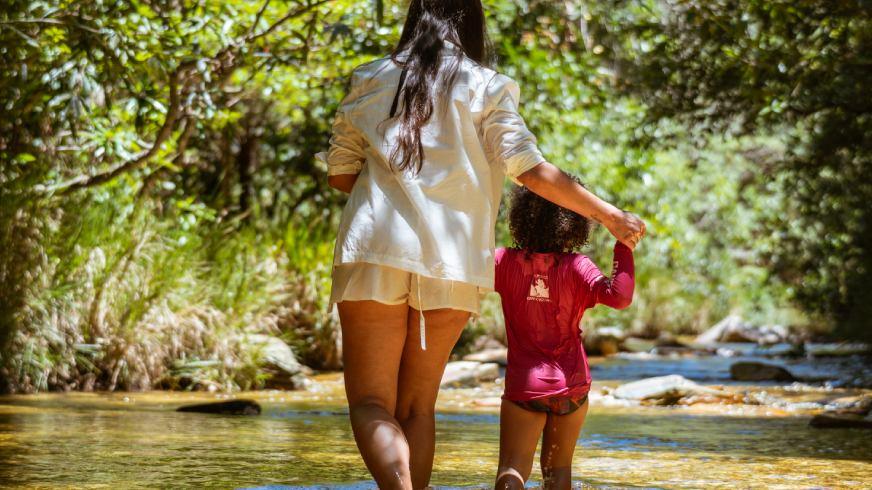 Sorrisos na Água: Por que a Canela de Ema é o Refúgio Preferido das Famílias em 2026. Acessibilidade, águas rasas e a paz que os pais de grandes centros precisam. Se você mora no Rio de Janeiro, Goiás ou no Distrito Federal, sabe que viajar com crianças exige planejamento logístico de guerra. Onde estacionar? O poço é fundo? Tem comida boa por perto? Na Canela de Ema, nós eliminamos essas perguntas da sua mente. Nossa Cachoeira No Limite é o paraíso para os pequenos. Com acesso facilitado (apenas 60 metros de caminhada leve), ela oferece poços de águas cristalinas com profundidade máxima de 3 metros, mas com amplas áreas rasas onde as crianças podem brincar com segurança total sob o olhar atento dos nossos guias. O "pulo do gato" para 2026 é o nosso Day Use Infantil. Criamos uma estrutura onde o lazer não cansa; ele renova. Enquanto os filhos exploram a natureza preservada do cerrado, os pais podem desfrutar do nosso ofurô natural, sabendo que estão em um ambiente controlado e seguro. Para as famílias que vivem a pressão dos grandes centros, o maior luxo é não ter que se preocupar com nada.