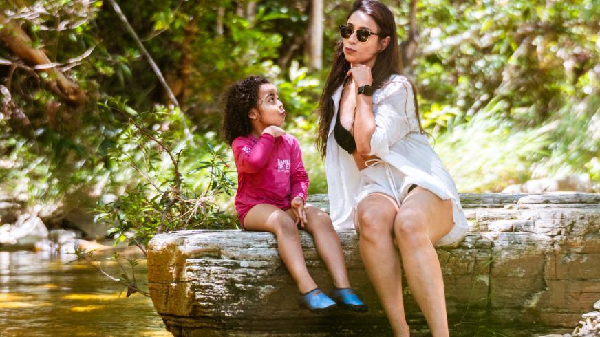 Sorrisos na Água: Por que a Canela de Ema é o Refúgio Preferido das Famílias em 2026. Acessibilidade, águas rasas e a paz que os pais de grandes centros precisam. Se você mora no Rio de Janeiro, Goiás ou no Distrito Federal, sabe que viajar com crianças exige planejamento logístico de guerra. Onde estacionar? O poço é fundo? Tem comida boa por perto? Na Canela de Ema, nós eliminamos essas perguntas da sua mente. Nossa Cachoeira No Limite é o paraíso para os pequenos. Com acesso facilitado (apenas 60 metros de caminhada leve), ela oferece poços de águas cristalinas com profundidade máxima de 3 metros, mas com amplas áreas rasas onde as crianças podem brincar com segurança total sob o olhar atento dos nossos guias. O "pulo do gato" para 2026 é o nosso Day Use Infantil. Criamos uma estrutura onde o lazer não cansa; ele renova. Enquanto os filhos exploram a natureza preservada do cerrado, os pais podem desfrutar do nosso ofurô natural, sabendo que estão em um ambiente controlado e seguro. Para as famílias que vivem a pressão dos grandes centros, o maior luxo é não ter que se preocupar com nada.